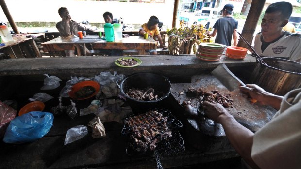 A cook prepares dog meat in Kaban Jahe, North Sumatra, Indonesia
