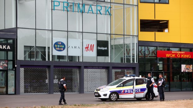 Police officers stand outside the Primark clothing store, in Villeneuve-la-Garenne, north of Paris, on Monday. Up to 10 employees were trapped inside with as many as three gunmen, police said.