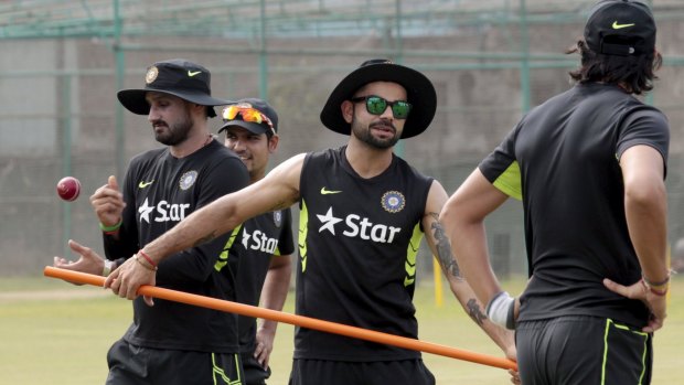 India captain Virat Kohli (centre) and bowler Harbhajan Singh (left) during a training session in Dhaka.