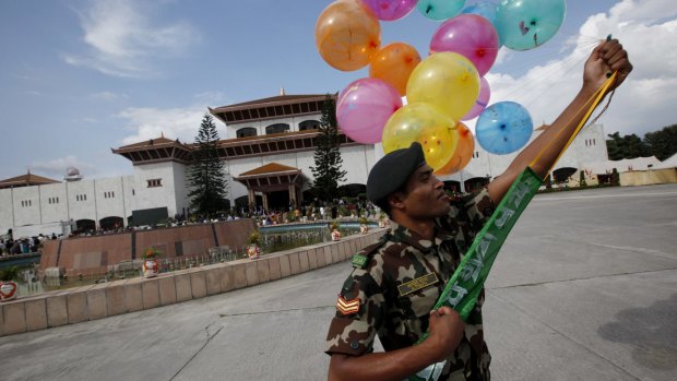 A Nepalese Army soldier holds balloons to decorate the constituent assembly on Sunday, in celebration of the nation's new constitution.