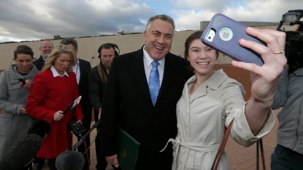 Treasurer Joe Hockey poses for a selfie with Anika Buining, during his Budget day press conference on the forecourt of Parliament House on Tuesday 12 May 2015. 