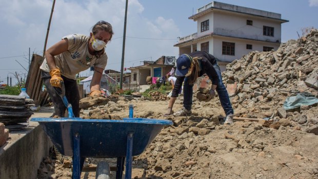 Katie Troy and Anika Fletcher clear rubble from a collapsed house in Baluwa village, north of Kathmandu.