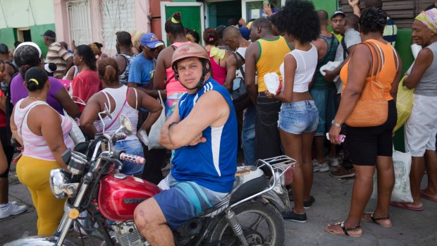 People crowd outside a shop to buy food prior the arrival of the Hurricane Matthew in Santiago, Cuba.