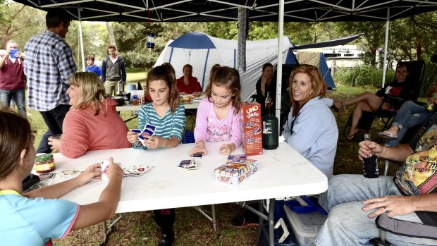 Taking cover: Members of the Wright, Bond, Dennis, Oliver, Neville and Sacilotto families enjoy Good Friday and the Easter vacation at Bonnie Vale camping ground in the Royal National Park.