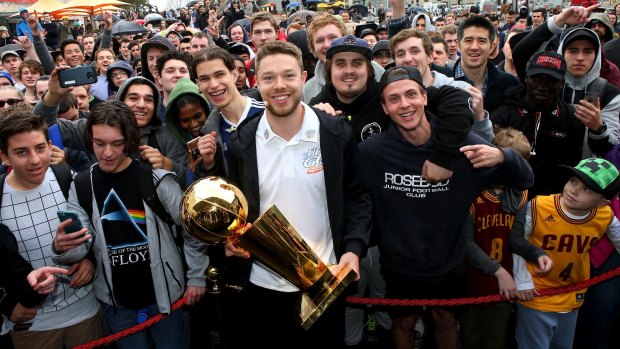 Matthew Dellavedova poses for a photo with the NBA trophy he won as part of the Cleveland Cavaliers championship team.