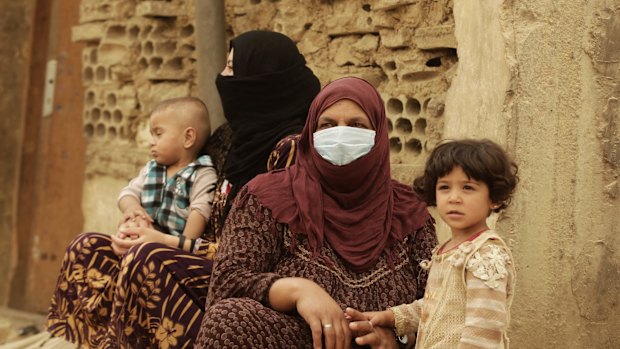 Syrian refugees cover their faces  during a sandstorm in a refugee camp in Lebanon.