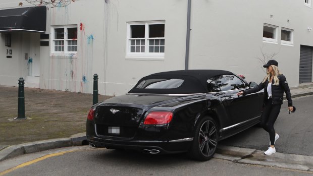 Roxy Jacenko opening the door of her $300,000 Bentley convertible outside the Paddington offices of Sweaty Betty, which were vandalised overnight. 