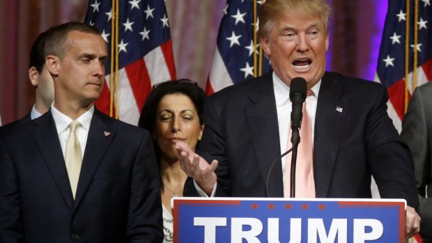 Donald Trump's campaign manager Corey Lewandowski listens as Mr Trump speaks in Palm Beach.