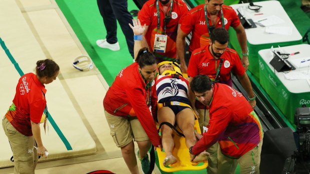 Samir Ait Said of France raises his arm to the crowd as he is stretchered off after breaking his leg.