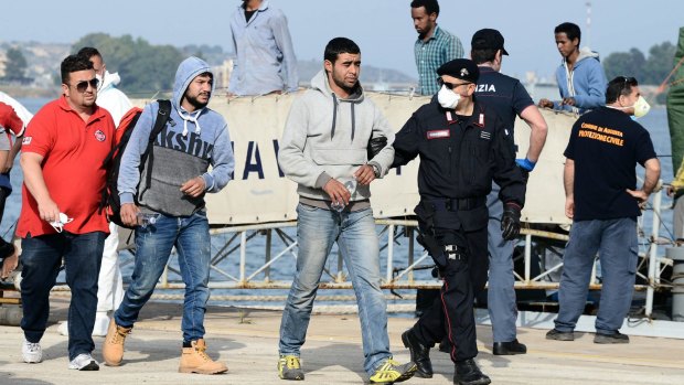 Migrants come ashore in Sicily on Thursday.