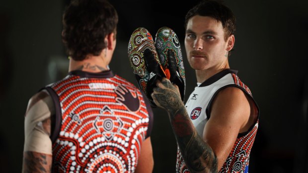 Man in the mirror: Nathan Wilson wearing the Indigenous jumper and with the special boots he will wear on Sunday against West Coast.