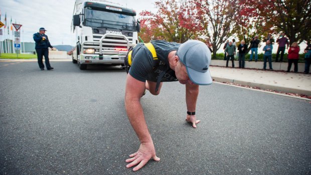 AFP Commander Grant Edwards pulls a 14-tonne police truck to prepare for his attempt at breaking a Guinness World Record. 