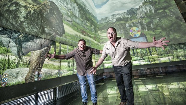 Sean Druitt (QUT's The Cube studio game manager) and palaenotologist Dr Scott Hocknull celebrating a very different kind of dinosaur exhibit.