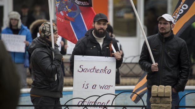 People with red and pro-Russian flags picket outside the court in Donetsk on Tuesday. 