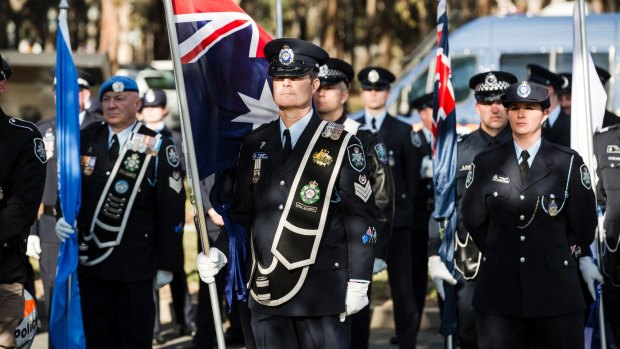 The National Police Memorial at Kings Park, Canberra. Protective service sergeant Stuart Williams holds the flag.