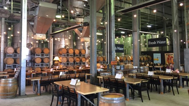 At Mt Duneed Estate, the Barrel Hall dining area is an impressive lofty industrial space, with huge steel vats suspended high above concrete floors.