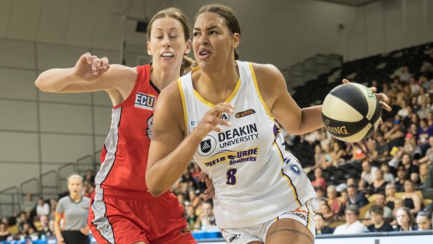 Fast break: Melbourne's Liz Cambage strides past Perth's Natalie Burton at the State Basketball centre on Sunday.