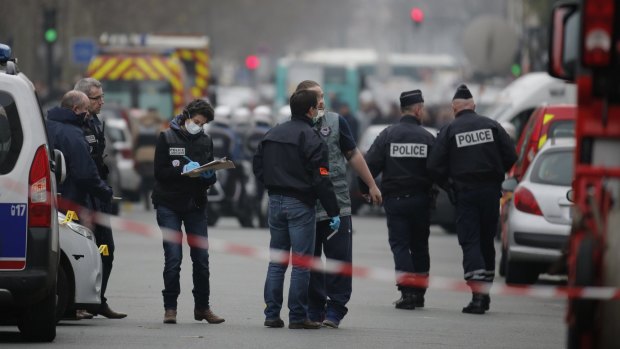 Forensic investigators examine the area near <i>Charlie Hebdo</i>'s Paris office after the January attack.