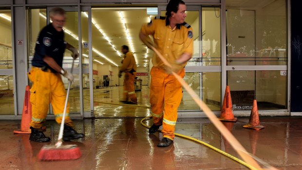 Rural fire service volunteers help clean up damaged shops in Lismore.