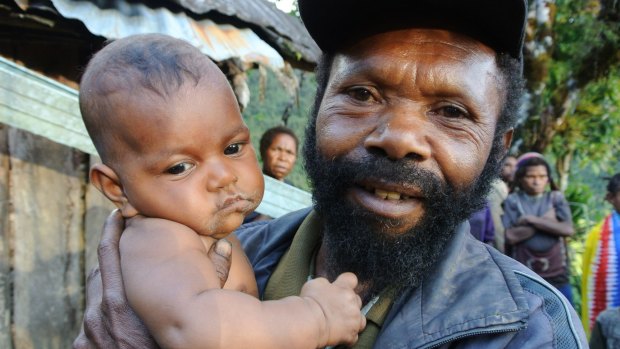 A villager at Lolat and his baby.