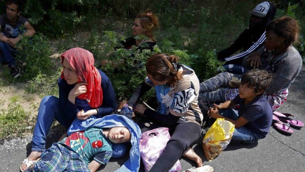 Migrants from Syria rest after crossing illegaly the border between Serbia and Hungary, near Asotthalom, Hungary July 14, 2015. Hungary started building a fence along its border with Serbia to try to stop illegal migrants entering from the south, a barrier which German Chancellor Angela Merkel has said makes "no sense". Tens of thousands of migrants, mainly from the Middle East and Africa, use the Balkans route to get into the European Union, passing from Greece to Macedonia and Serbia and then to the EU's visa-free Schengen zone that starts in Hungary.    REUTERS/Laszlo Balogh TPX IMAGES OF THE DAY