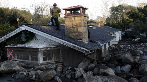 A house is submerged by mud and boulders following the mudslide in Montecito, California. 