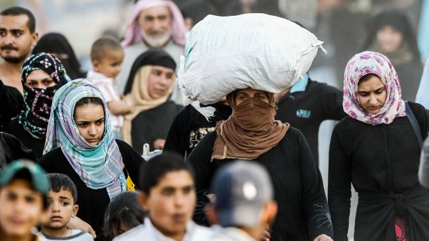 Syrian refugees cross into Turkey at Akcakale on Monday. 