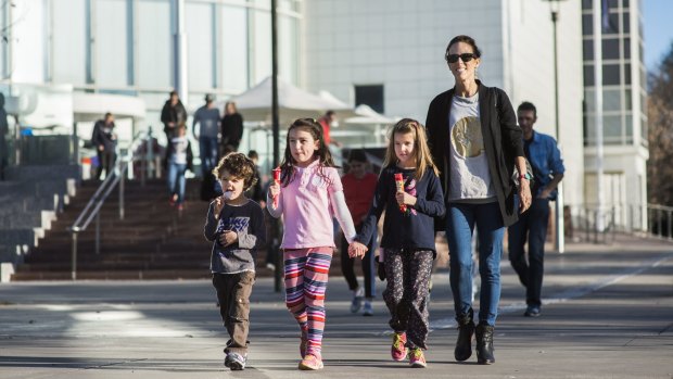 Lisa Postles with Angus Postles, 4, Charlotte Wood, 7, and Abbie Postles, 6, walk with ice creams after their visit to Questacon.