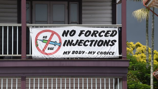 A sign declaring "No Forced Injections" a building on the main street.