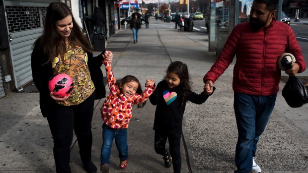 Rachel McCormick and her husband Irvi Cruz hold hands with their daughters, Ana Cruz-McCormick, 2, and Sara Cruz-McCormick, 4.