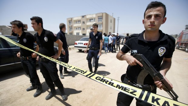 Security guards cordon off a building after two police officers were found shot dead in Ceylanpinar.