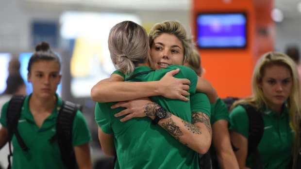 Triumphant return: Matildas player Michelle Heyman hugs a teammate after arriving at the Sydney International Airport on Friday.