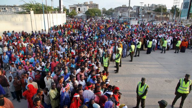 Protesters gather near the scene of Saturday's massive truck bomb attack, near the presidential palace, in Mogadishu.