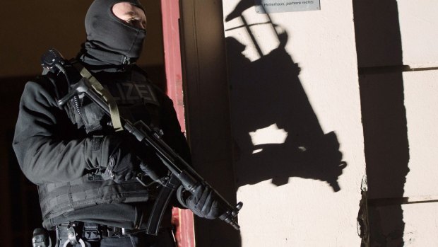 Special police force guards the entrance of a house in Berlin during an anti-terrorism raid.