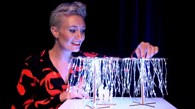 Lucy Keeler with a scale model of the light installation titled Let it Snow.