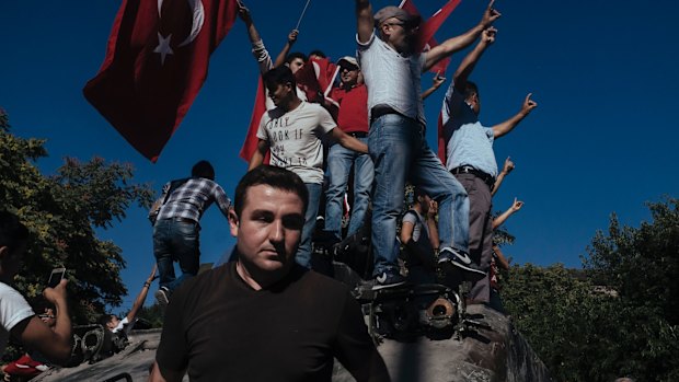 Protesters climb a damaged  tank in Ankara after the failed July 2016 coup.