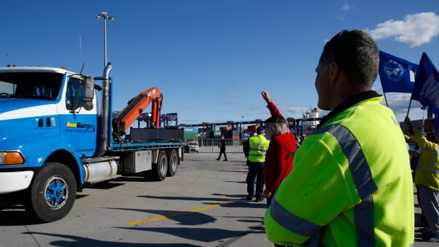 Hutchison Ports Australia workers stop a truck entering at Port Botany, Sydney, after being sacked by email overnight.