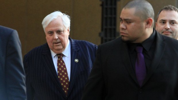 Clive Palmer was flanked by security guards as he left court on Monday.