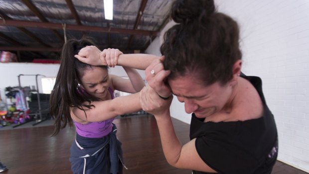 Kiana Gallop-Angeles (left) and Emily Constantine practise hair pulling at The Sydney Stage Combat School.