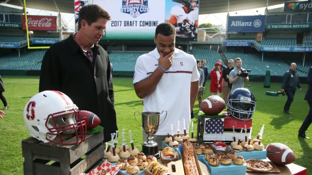 Three-time Super Bowl champion Ed McCaffrey, left, and Solomon Thomas, defensive end for the San Francisco 49ers, look over a sampling of food that will be available to fans during a promotion for the Sydney Cup in Sydney, Australia, Thursday, May 18, 2017. Stanford University and Rice will play the opening game of the college football season in Sydney on August. 27.