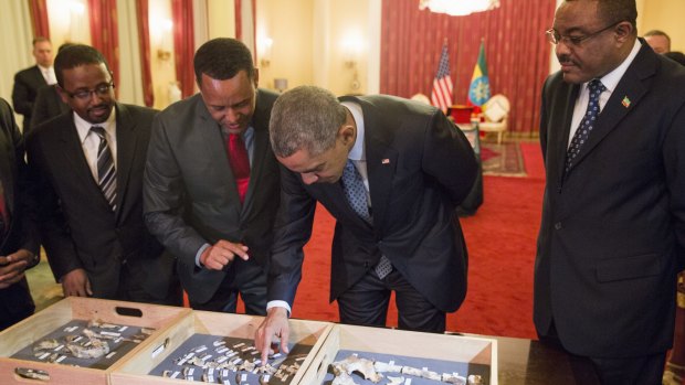 Ethiopian Prime Minister Hailemariam Desalegn watches as President Barack Obama touches "Lucy," part of several hundred pieces of bone representing 40 percent of a female Australopithecus afarensis who was estimated to have lived 3.2 million years ago in Ethiopia.
