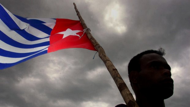 A Papuan holds the Morning Star independence flag, an act for which dissident Filep Karma was jailed for 15 years.
