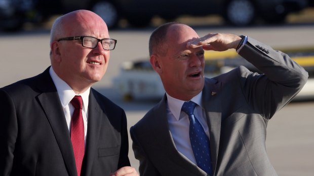 Senator George Brandis and Queensland Premier Campbell Newman watch Air Force One land.