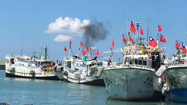 Taiwanese fishing boats flying national flags prepare to leave for the Taiwan-controlled Taiping Island.