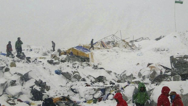 People approach the scene after an avalanche triggered by a massive earthquake swept across Everest Base Camp.