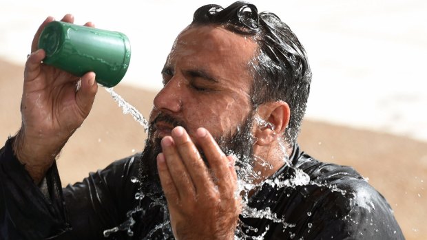 A Pakistani Muslim man cools down with water at a mosque during a heatwave in Karachi on Monday.