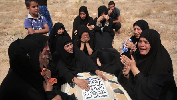 Women mourn over a relative at a cemetery in the holy city of Kerbala, south-west of Baghdad.