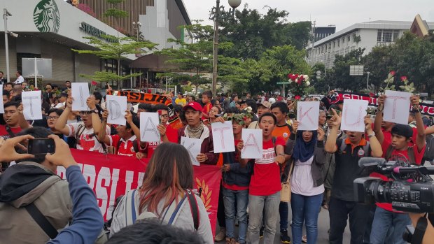 Jakarta football club supporters sing while holding letters saying "kami tidak takut" ('We are not afraid') at an anti-terrorism rally outside Starbucks where a suicide bomb was detonated.