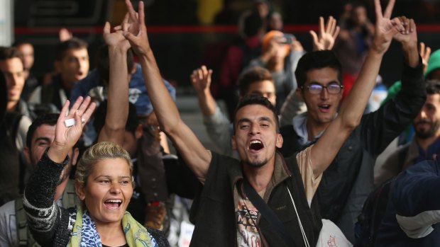 Migrants arriving on a train from Hungary react to the welcoming cheers of onlookers at Munich's main railway station in September.