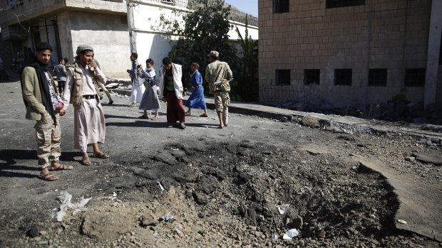 People stand around a crater made by a Saudi-led coalition airstrike in Sanaa, Yemen, last Friday. 